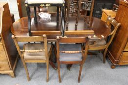 A George III design mahogany twin pillar extending dining table with two leaves.