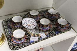An eastern enamelled small tray with a set of six matching cups and saucers and a similar dish.
