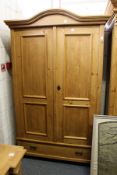 A continental pine two-door armoire with a drawer to the base.