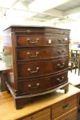 A George III style mahogany bow front four drawer chest with brushing slide.