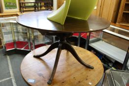 A mahogany circular extending dining table.