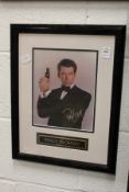 A signed photograph of Pierce Brosnan, framed and glazed.