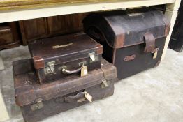 Two leather suitcases and a dome top trunk.