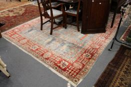 A large modern Persian style carpet, pale blue ground with stylized decoration.