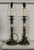 A pair of metal candlestick form lamp bases.