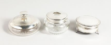 A circular silver jewellery box and two silver mounted cut glass dressing table items.