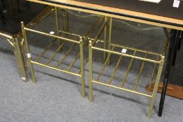 A pair of stylish brass framed two tier glass topped lamp tables.