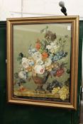 A good silk work embroidered picture depicting flowers in a vase on a ledge, in a gilt frame.