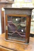 A small mahogany hanging corner cupboard.