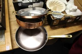 Two good quality copper and brass frying pans and a similar twin handled dish.