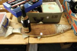 A fish shaped serving board and an old bottle of champagne.
