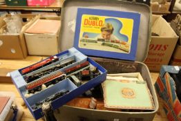 A suitcase containing a Hornby train set and other items.