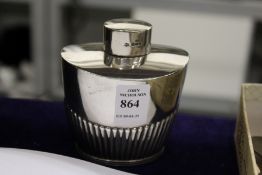 A silver oval shaped tea caddy.