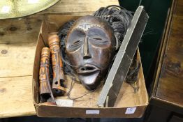 An African carved wood mask with hair and various other items.