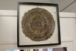 A circular feather picture, framed and glazed.