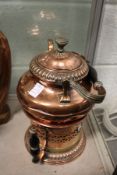 A copper kettle on stand.