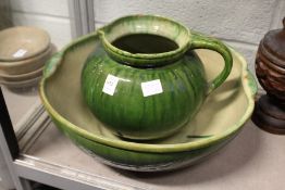 An Arts and Crafts green glazed pottery jug and bowl set (chipped).