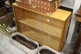 A 1970's bookcase with glass sliding doors in the manner of Alvar Aalto.