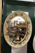 A Capodimonte porcelain mirror, the frame decorated with cherubs.