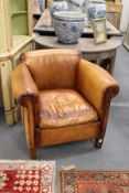 A brown leather upholstered club style armchair.