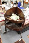 A mahogany corner wash stand complete with porcelain jug and bowl.