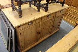 A pine dresser base with three drawers and three cupboard doors.
