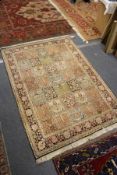 A Persian rug, beige ground with five rows of seven square shaped decorative panels.