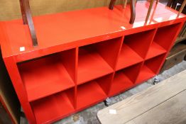 A stylish red lacquer eight division storage trolley.