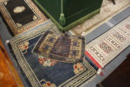 Four small Persian style rugs.