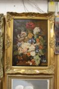 A still life of flowers in a vase on a ledge, oil on canvas, in a decorative gilt frame.