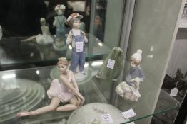 Three Lladro figures and a carved hardstone penguin.