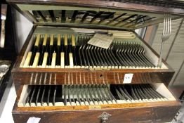 An oak cased two tier canteen of cutlery.