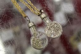Two novelty pendants and chains.
