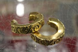 A pair of large decorative earrings.