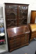 A George III mahogany bureau with associated bookcase top.