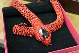 A decorative red stone snake necklace.