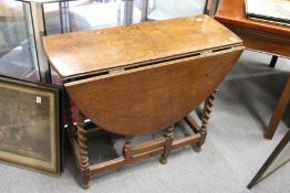 An oak drop leaf gate leg barley twist dining table.
