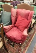 A George II style armchair upholstered in a classical crimson ground fabric on cabriole legs.