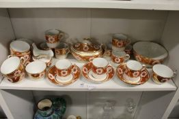 A late 19th century part tea service, possibly Spode, decorated in the classical style with orange
