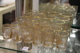 A collection of gilt decorated small cut glass beakers.