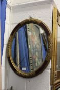A decorative oval wall mirror.