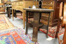 A pair of orientalist oak lamp tables with metal mounts.