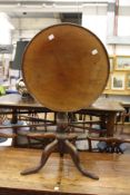 A mahogany circular tilt top tripod table.