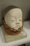 An unusual pottery sculpture of a baby's head.
