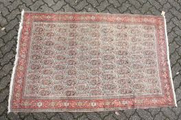 A PERSIAN SENNA RUG, early 20th century, beige ground with Boteh decoration within a red ground