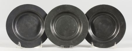 THREE EARLY PEWTER CIRCULAR PLATES, stamped LONDON. 7ins diameter.