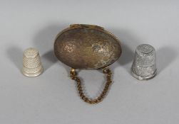 TWO THIMBLES, one in an egg (2).