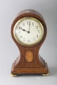 A SMALL EDWARDIAN MAHOGANY INLAID BALLOON SHAPED CLOCK on four brass ball feet. 8.5ins high.