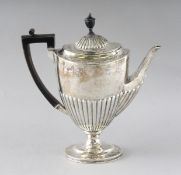 A MATCHING OVAL HALF FLUTED COFFEE POT with ebony handle. London 1893. Weight 19ozs.