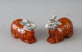 A PAIR OF AMBER RABBITS with silver heads.